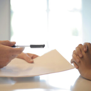 two people working together with paper and pen